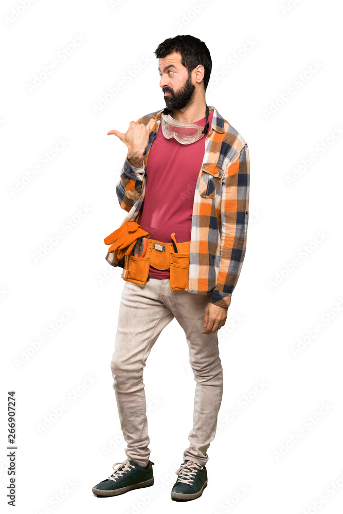 Craftsmen man unhappy and pointing to the side over isolated white background Craftsmen man unhappy and pointing to the side over isolated white background