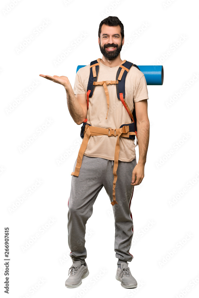 Hiker man holding copyspace imaginary on the palm to insert an ad over isolated white background Hiker man holding copyspace imaginary on the palm to insert an ad over isolated white background