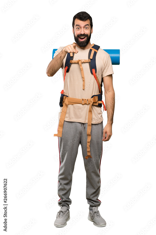 Hiker man surprised and pointing front over isolated white background Hiker man surprised and pointing front over isolated white background