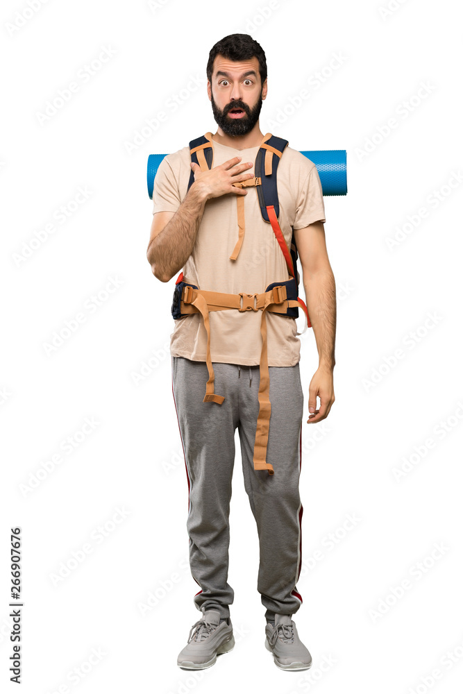Hiker man surprised and shocked while looking right over isolated white background Hiker man surprised and shocked while looking right over isolated white background