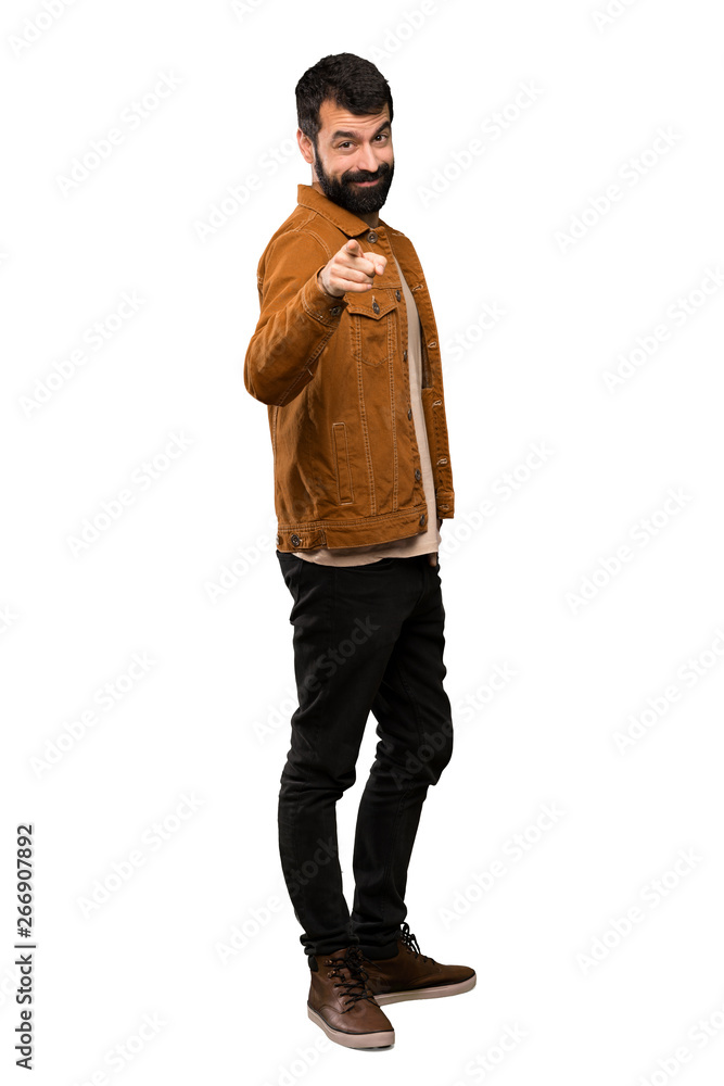 Handsome man with beard points finger at you with a confident expression over isolated white background