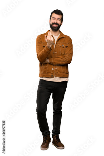 Handsome man with beard inviting to come with hand. Happy that you came over isolated white background