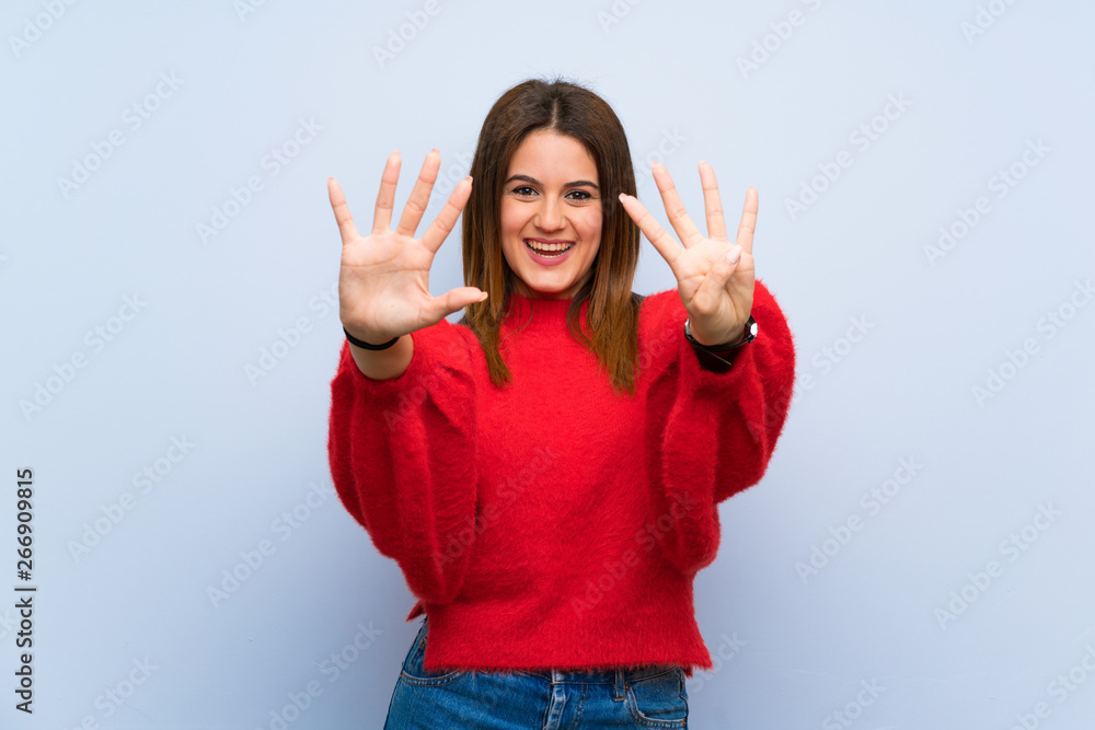 Young woman over isolated blue wall counting nine with fingers Young woman over isolated blue wall counting nine with fingers