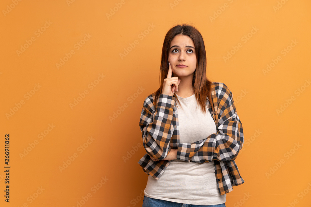 Young woman over brown wall Looking front Young woman over brown wall Looking front
