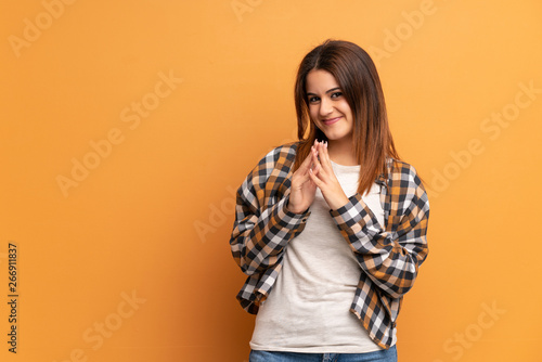 Young woman over brown wall scheming something