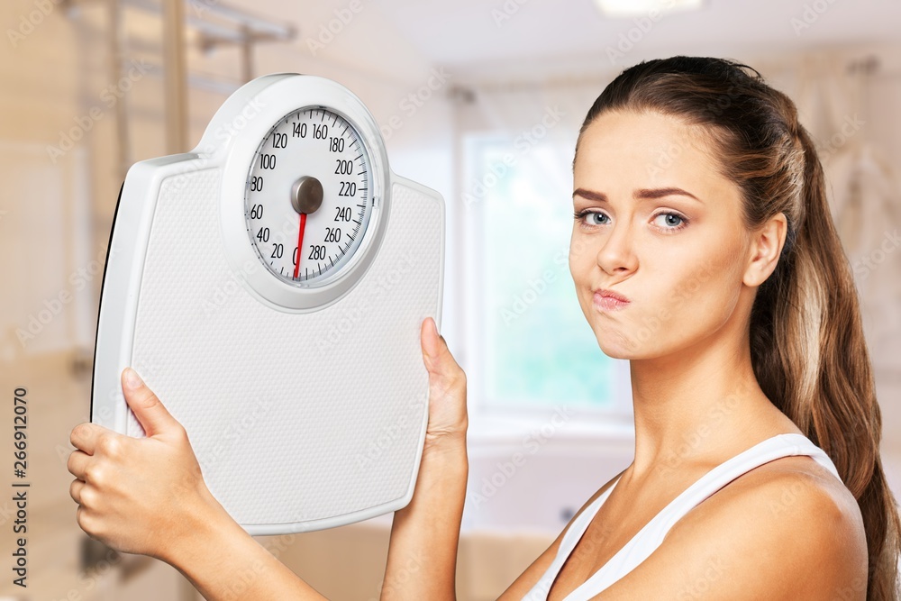 Beautiful young s woman holding scales Stock Photo Adobe Stock