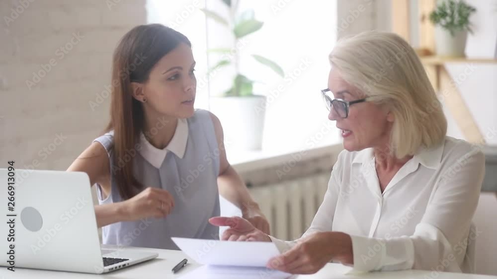 Angry old client arguing meeting young manager on insurance dispute Angry old client arguing meeting young manager on insurance dispute