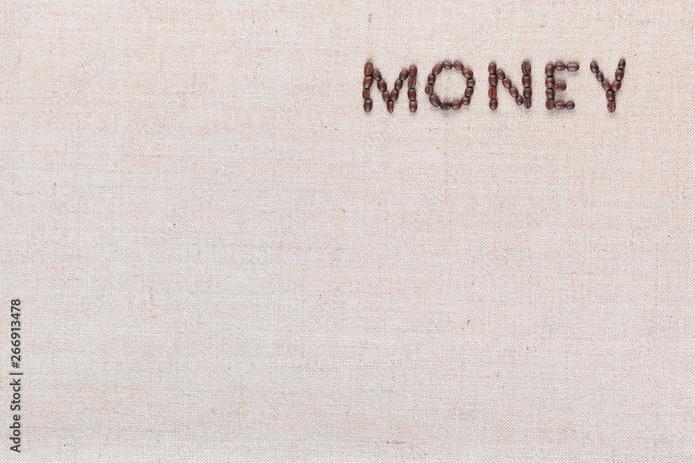 Money written with coffee beans on linen texture, arranged top right.
