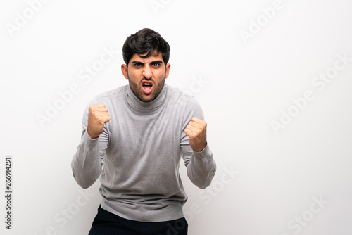 Young man over isolated white wall frustrated by a bad situation