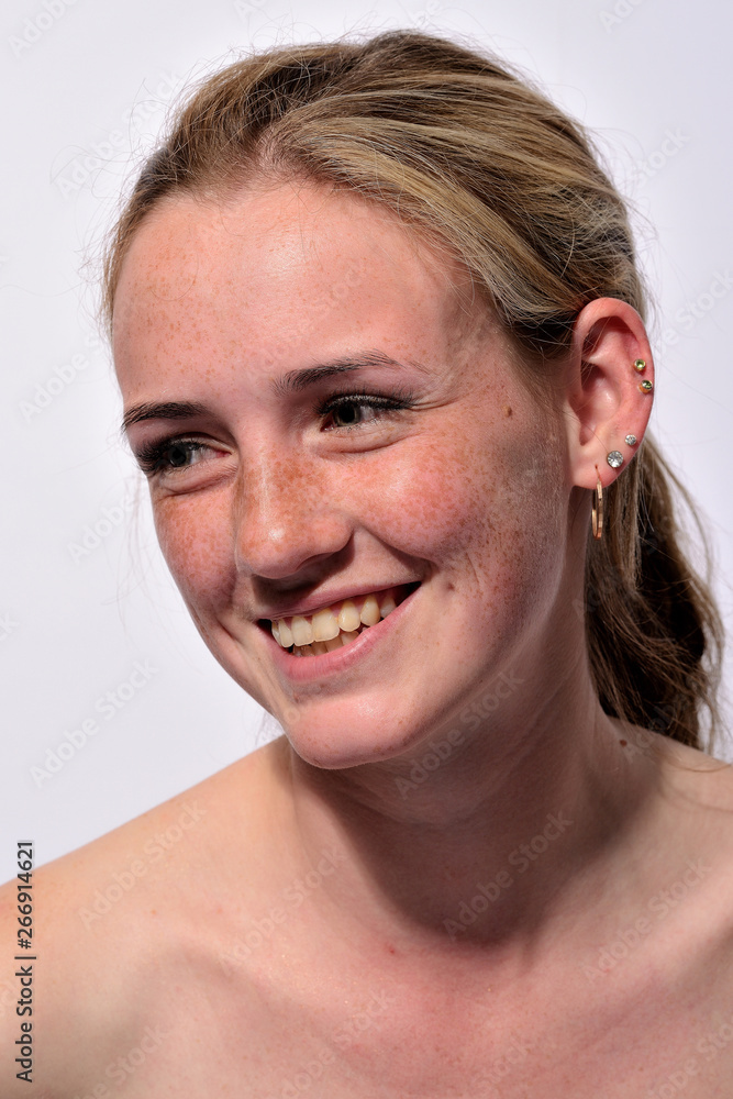 Obraz premium portrait of a young beautiful girl with blue eyes and freckles on a white background