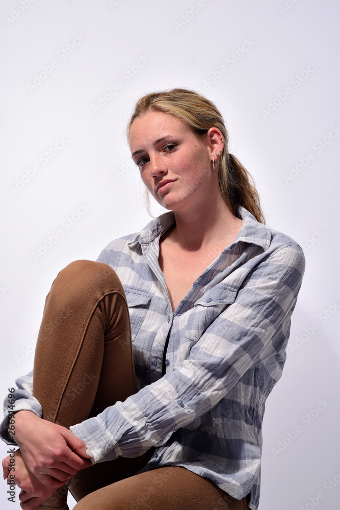 portrait of a young beautiful girl with blue eyes and freckles on a white background