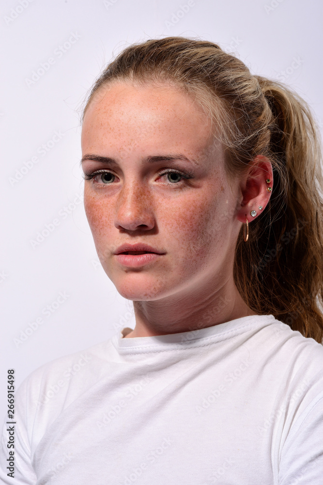 Obraz premium portrait of a young beautiful girl with blue eyes and freckles on a white background