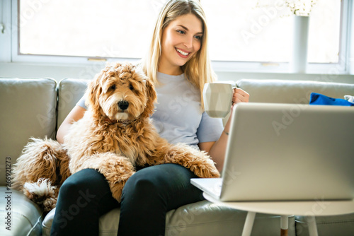 Photography woman with his Golden Labradoodle dog at home drinking coffee