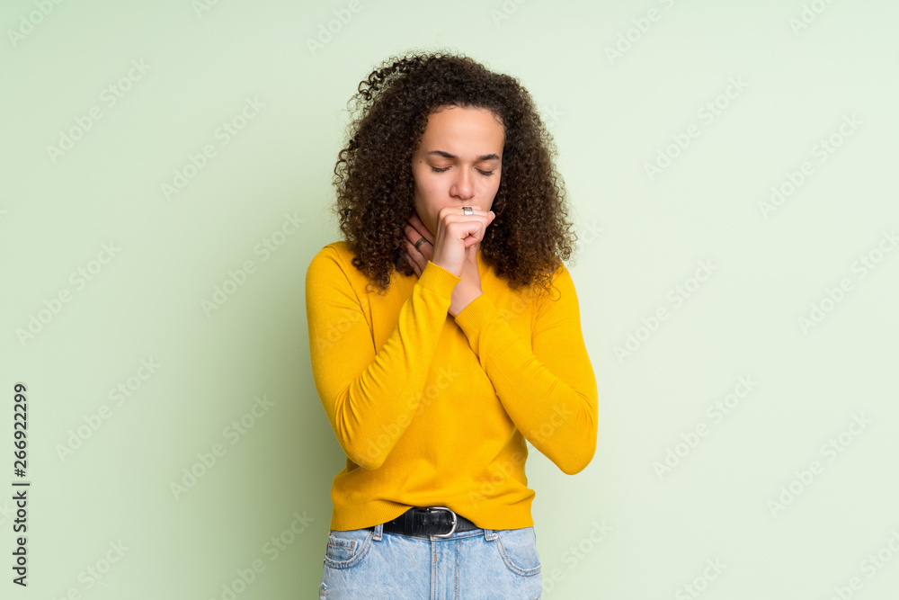 Dominican woman over isolated green background is suffering with cough and feeling bad Dominican woman over isolated green background is suffering with cough and feeling bad