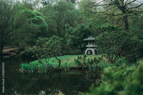 Stone lantern in a Japanese garden with lake © Maksim Chekmarev