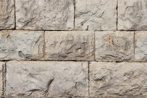 Stone natural wall in blocks. The texture of the stone block-lined wall of natural yellowing stone.