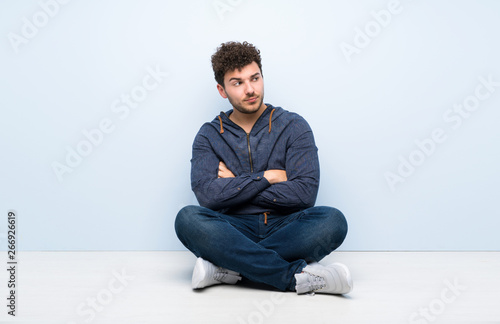 Young man sitting on the floor portrait © luismolinero