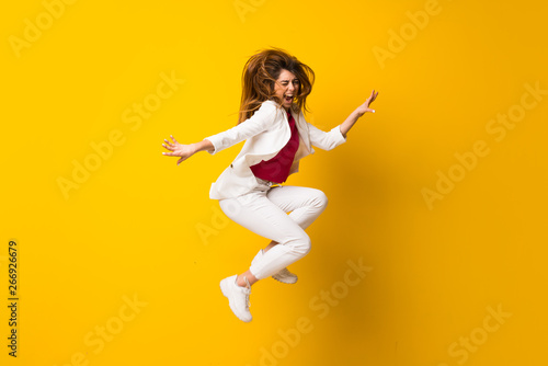 Fototapeta Naklejka Na Ścianę i Meble -  Young woman jumping over isolated yellow wall