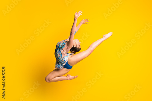 Girl doing rhythmic gymnastics jumping photo