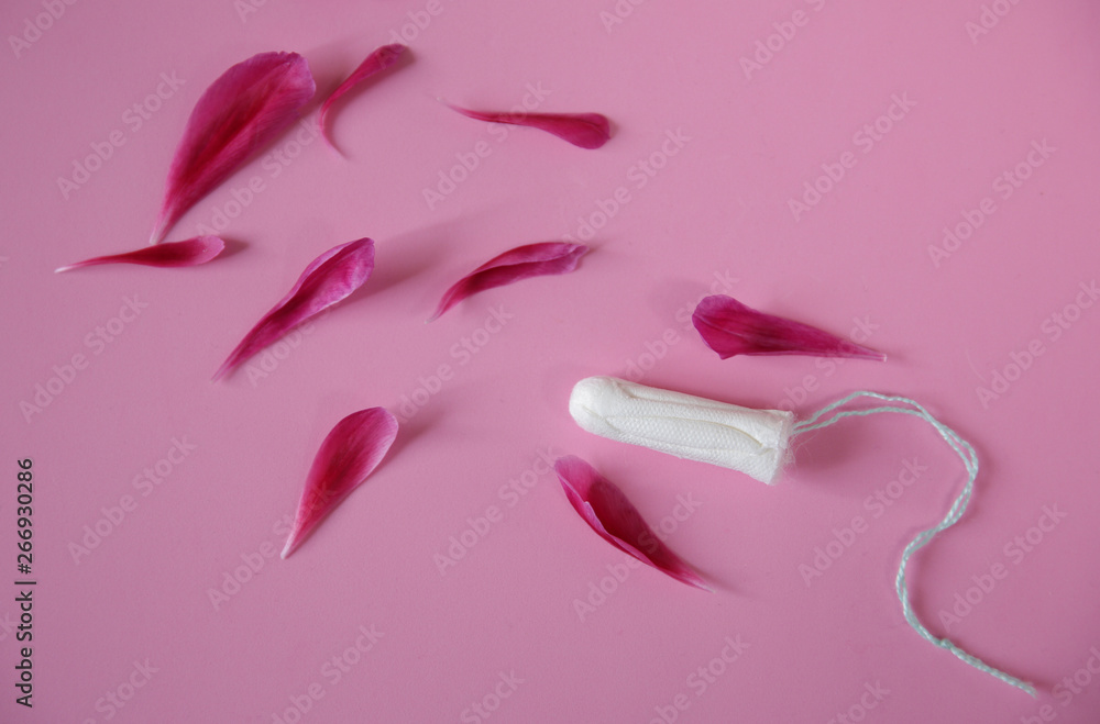 Clean white cotton tampon with red peony petals on pink background. Menstruation. Feminine Hygiene in periods, beauty treatment. Flat lay. Clean white cotton tampon with red peony petals on pink background. Menstruation. Feminine Hygiene in periods, beauty treatment. Flat lay.