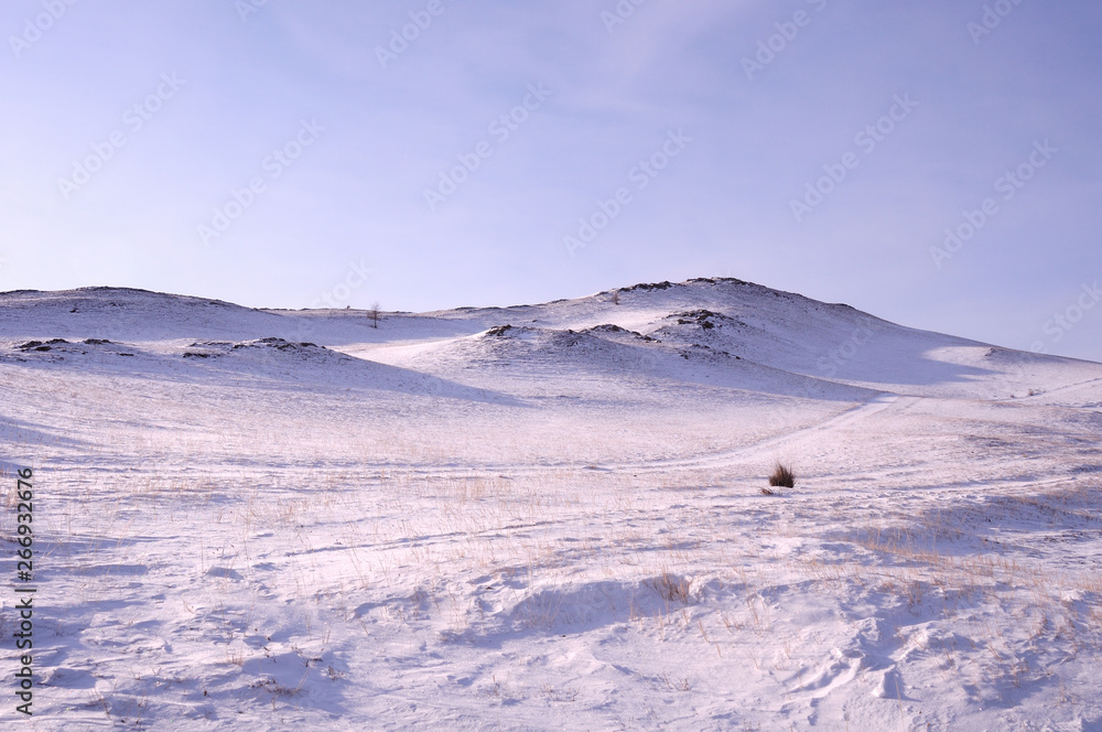 Early morning sunrise in Tazheran steppes. Snow-covered hills are colored in shades of ultra-violet. Photo toned. Early morning sunrise in Tazheran steppes. Snow-covered hills are colored in shades of ultra-violet. Photo toned.