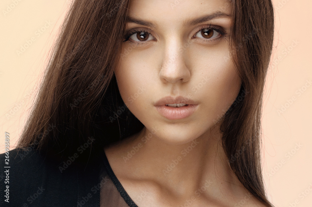 Close up of a brunette girl with seductive and natural make up, long hair, looking at camera, dressed in black. Close up of a brunette girl with seductive and natural make up, long hair, looking at camera, dressed in black.