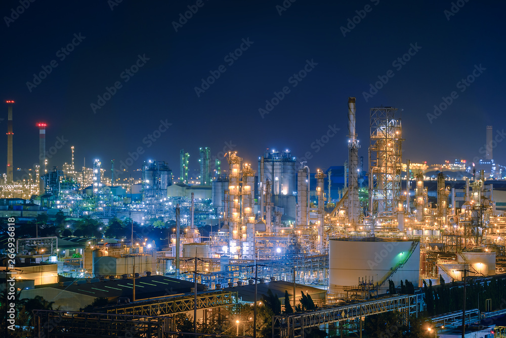 Oil and Gas refinery industry plant with glitter lighting, Factory of petroleum industrial at night time, Petrochemical plant with gas distillation tower and storage tank