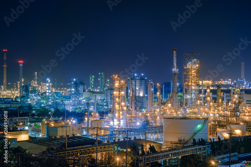 Oil and Gas refinery industry plant with glitter lighting, Factory of petroleum industrial at night time, Petrochemical plant with gas distillation tower and storage tank