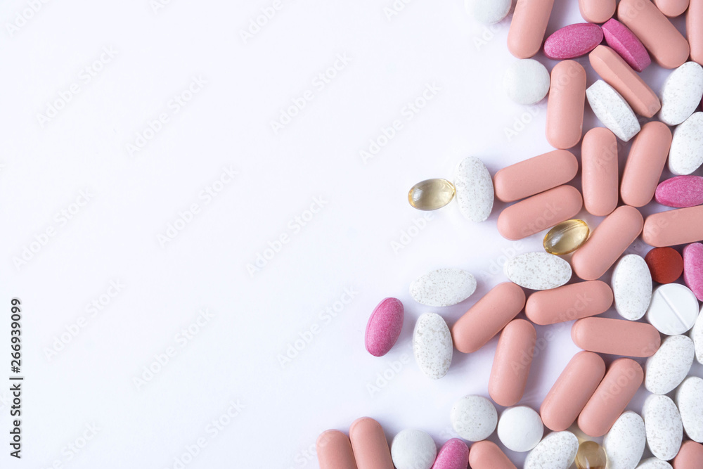 many pills and drugs in bright colors on white background many pills and drugs in bright colors on white background