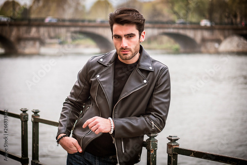 Obraz na płótnie One handsome young man in urban setting in modern city, standing, wearing black