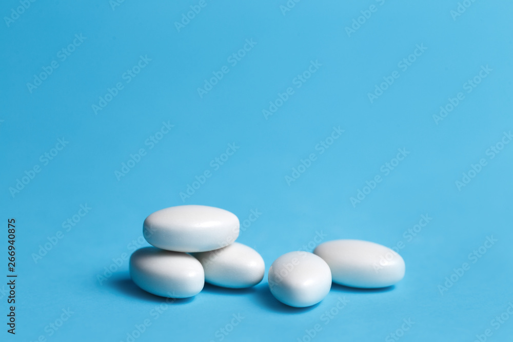 Heap of white pills on blue background. Medical, pharmacy and healthcare concept. Heap of white pills on blue background. Medical, pharmacy and healthcare concept.