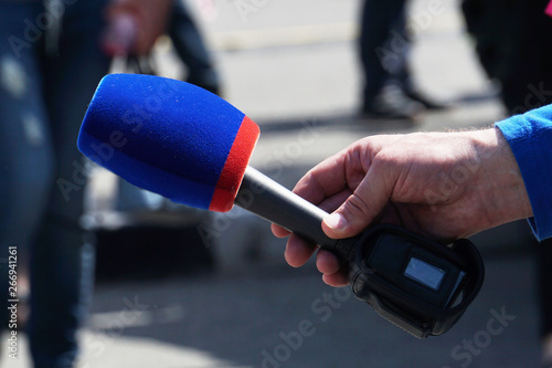 Microphone in the correspondent`s hand.TV interview