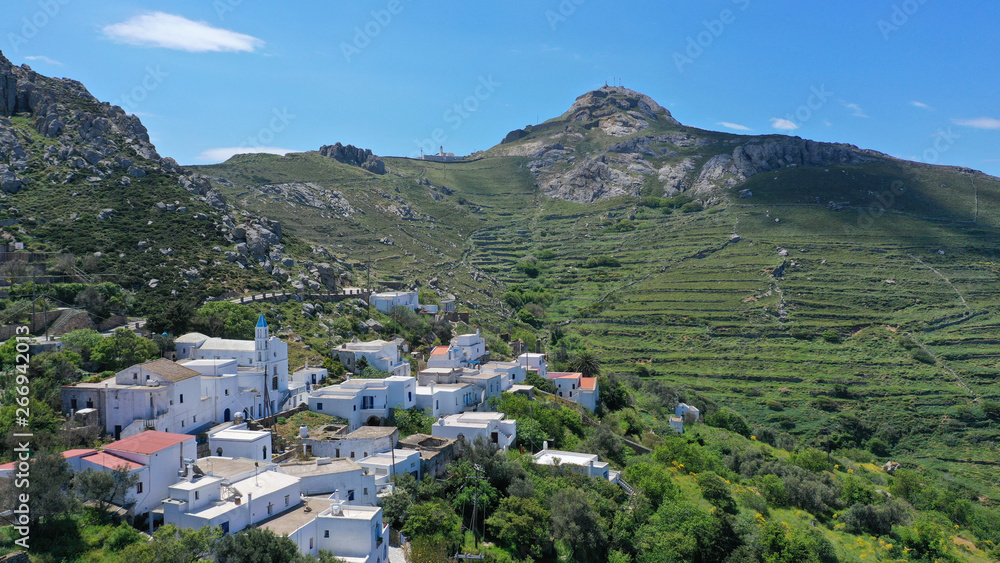 Aerial drone photo of picturesque traditional village of Koumaros in the slopes of mountain and castle of Exomvourgo or Exombourgo with beautiful deep blue sky, Tinos island, Cyclades, Greece