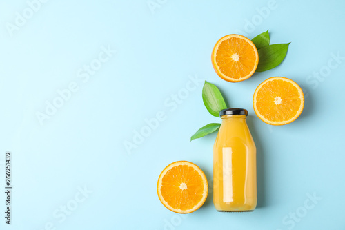 Bild auf Leinwand Flat lay composition with fresh orange juice in bottle and oranges with leaves on color background, space for text
