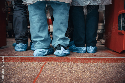 people in plastic shoe liners in food production, hygiene measures