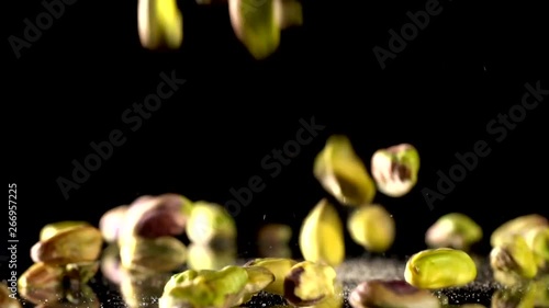 Pistachios falling on a black background in slow motion