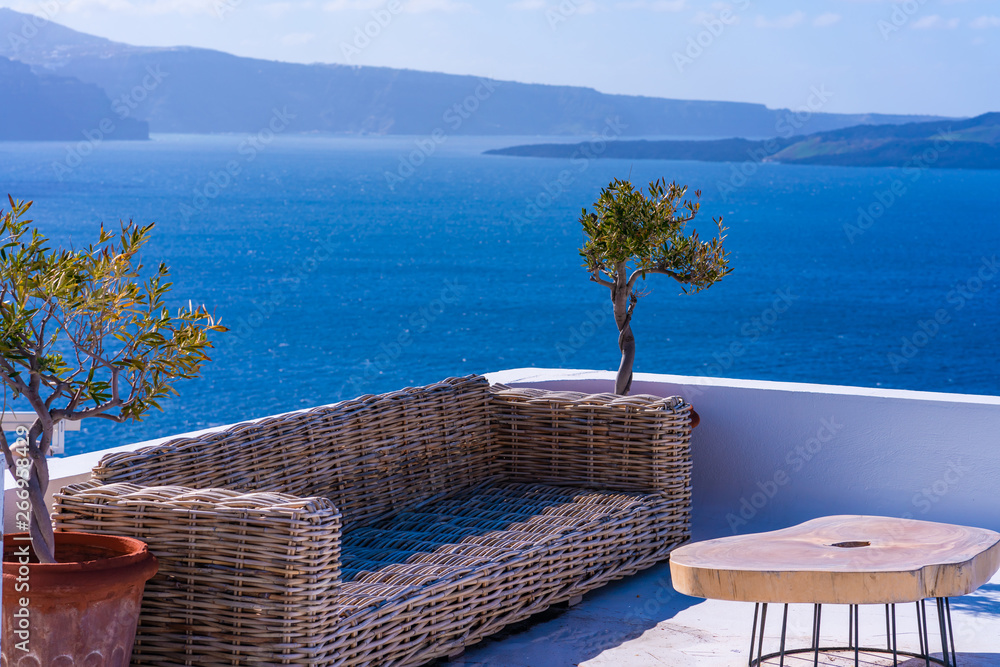 Obraz premium Table and sofa on a tarrace with view of Aegean Sea in Oia. Santorini, Cyclades, Greece
