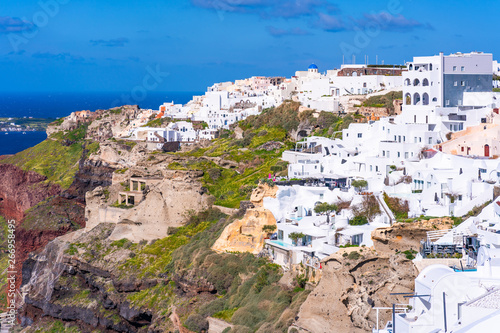 View of Oia, a coastal town on Greek island Santorini. The town has whitewashed houses carved into the rugged clifftops. © beataaldridge