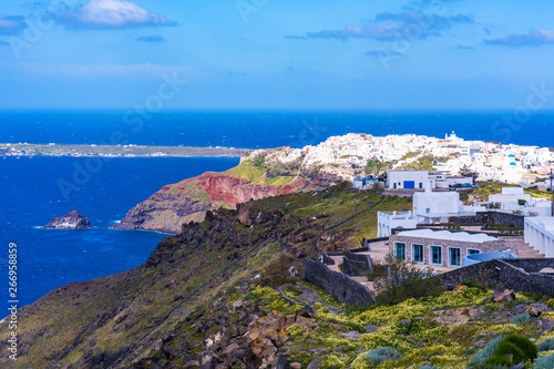 View of Oia, a coastal town on Greek island Santorini. The town has whitewashed houses carved into the rugged clifftops.