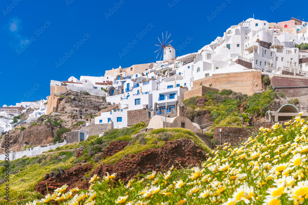 Santorini landscape with view of whitewashed buildings and windmills in Oia, Greece