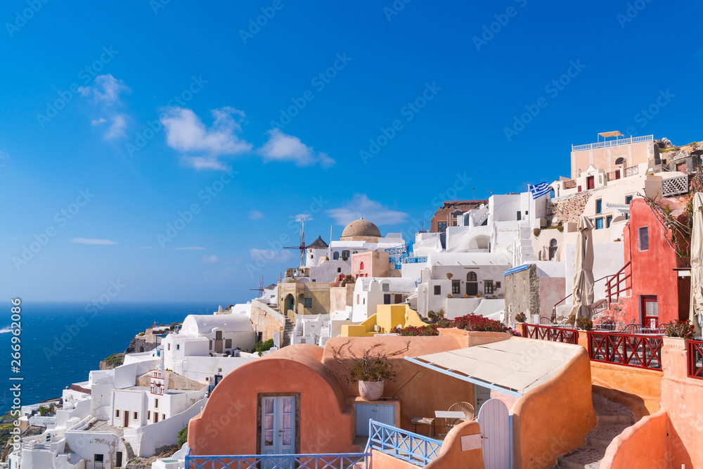 Santorini landscape with view of whitewashed buildings and windmills in Oia, Greece