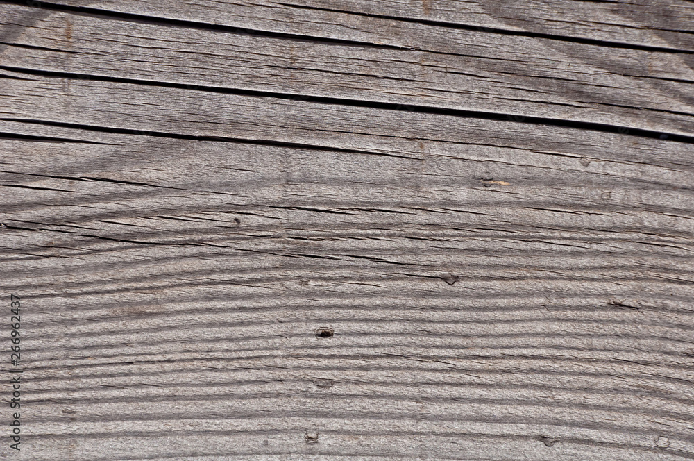Fototapeta premium Texture photo of grey, worn, shabby, old and cracked wood which was exposed to weather and sun for years. Ideal as a background.