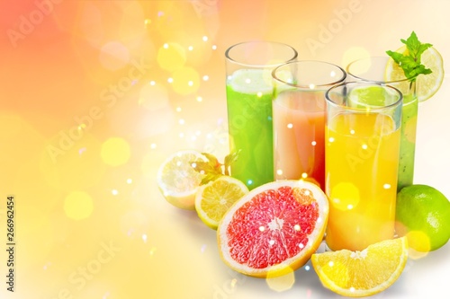 Tasty fruits and juice with vitamins on background