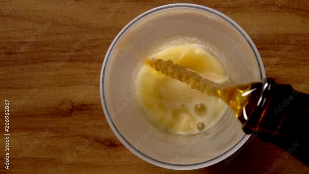 Cold beer pouring in the cup in slow motion Cold beer pouring in the cup in slow motion