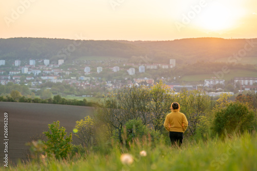 Woman in a yellow jacket enjoying a beautiful sunset over Jena in Thuringia
