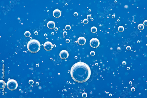 Bubbles of oxygen surging upward in blue water.