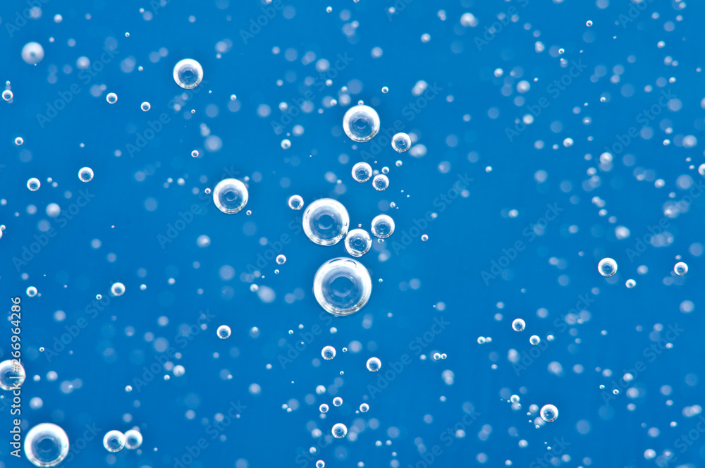 Bubbles of oxygen surging upward in blue water.