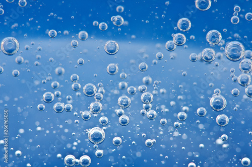 Bubbles of oxygen surging upward in blue water.