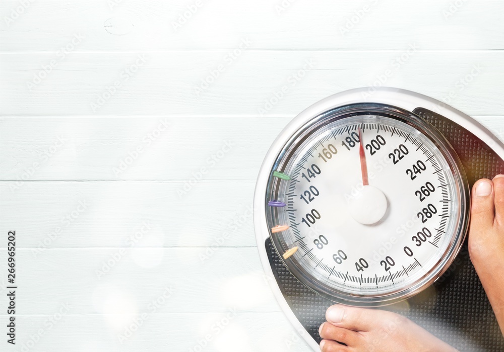 Bare female feet standing on bathroom scale Bare female feet standing on bathroom scale