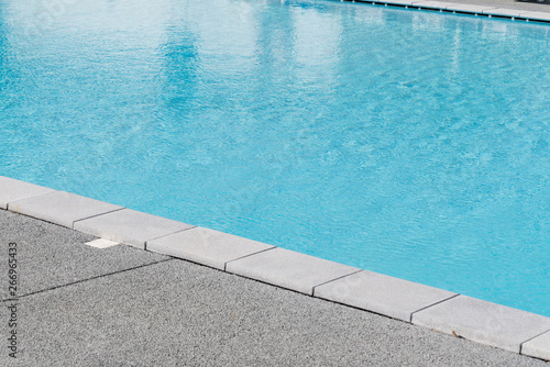 Edge of swimming pool with blue water